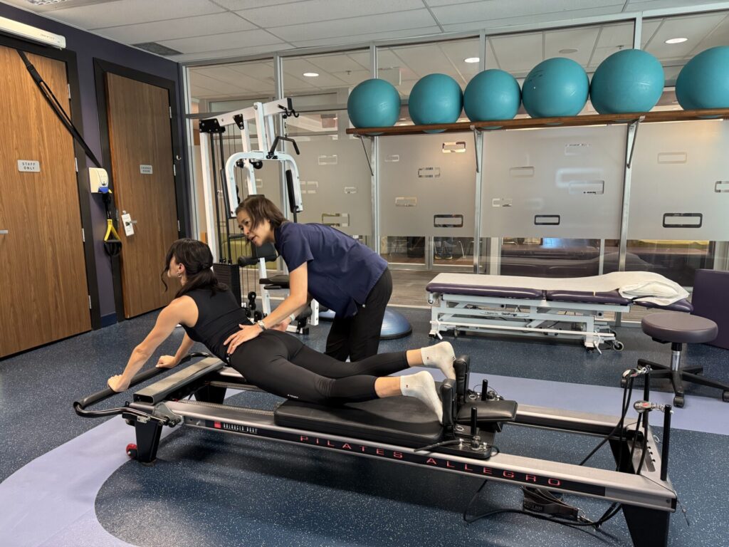 Vancouver physiotherapist Winnie Chan giving instructions to patient doing clinical pilates exercises at Cross Roads Physiotherapy & Massage Therapy clinic